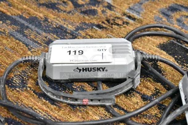Husky String Lights power box with attached cables on a carpet. Features auction tag "119" from PCI Auctions.