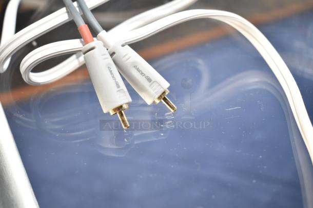 White audio cables with gold-plated connectors labeled "Binary," coiled on a reflective surface.