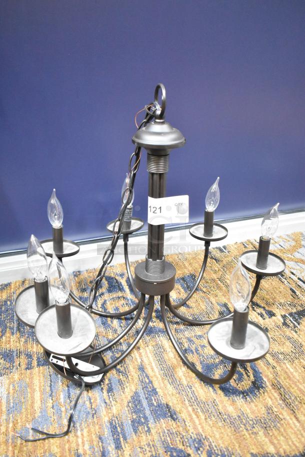 Black finish chandelier with six candle-style lights, modern design. Includes chain for hanging. Auction tag visible.