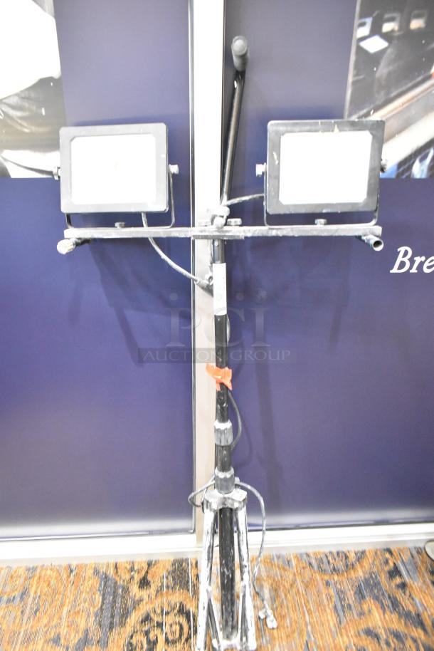 2 Head work light on tripod stand. Features adjustable lights, sturdy tripod, some wear visible, includes power cable.