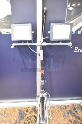 2 Head work light on tripod stand. Features adjustable lights, sturdy tripod, some wear visible, includes power cable.