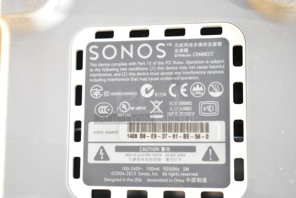 Sonos Connect label showing model, FCC compliance, serial number, and caution warning. Designed in USA, assembled in China.