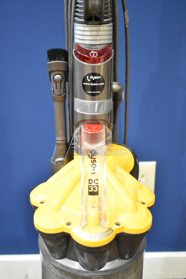 Dyson DC33 Vacuum Cleaner, 115 Volts, 1 Phase, yellow and gray, good condition, visible branding and model markings.
