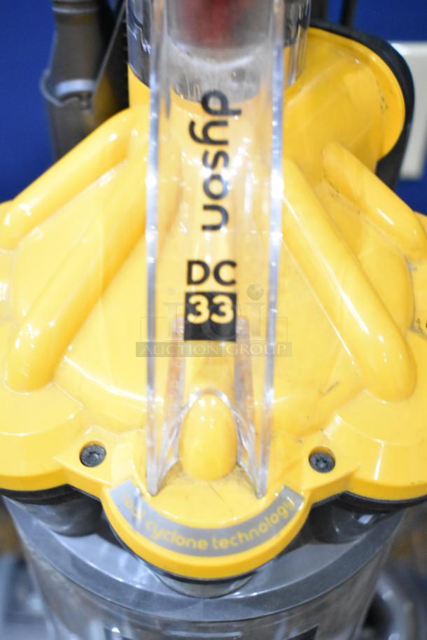 Dyson DC33 Vacuum Cleaner with 115 Volts, 1 Phase. Visible logo and model details. Features root cyclone technology.