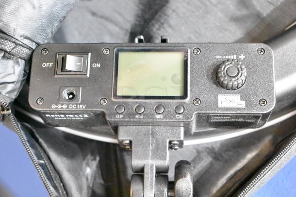 Digital control panel close-up with on/off switch, dial, display, and Pixel logo. Part of auction set with frames and bag.