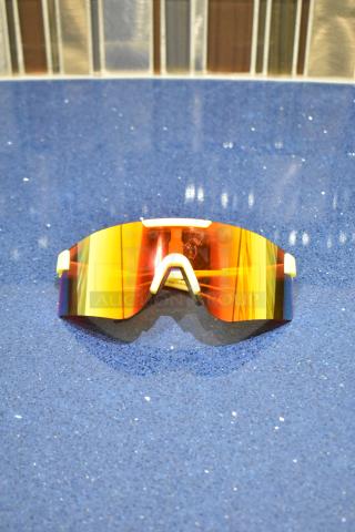 Brand new yellow framed sunglasses with BluBlocker orange lens on blue surface.