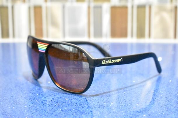 Brand new BluBlocker sunglasses, black frame, brown lenses, BluBlocker logo on arms, multicolor stripe detail, pristine condition.