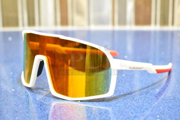 Brand new white-framed sunglasses with BluBlocker orange lenses, featuring a modern design and "BluBlocker" marking on the side.