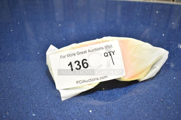 BRAND NEW white framed sunglasses with BluBlocker orange lens, wrapped, auction tag number 136 visible.