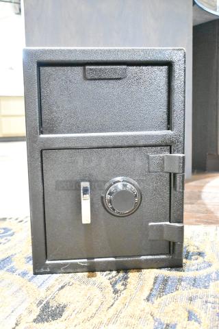 Black single compartment drop safe, sturdy build, no combination provided, features a dial lock, minor scuffs visible.