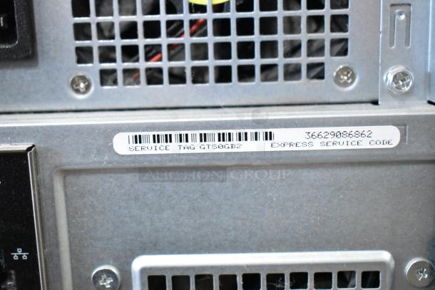 Dell computer tower back panel with vents and visible service tag GTS06B2; missing hard drive.