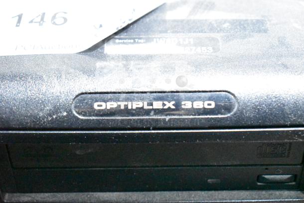 Dell Optiplex 360 computer tower, missing hard drive, with visible service tag and branding. Shows signs of wear.