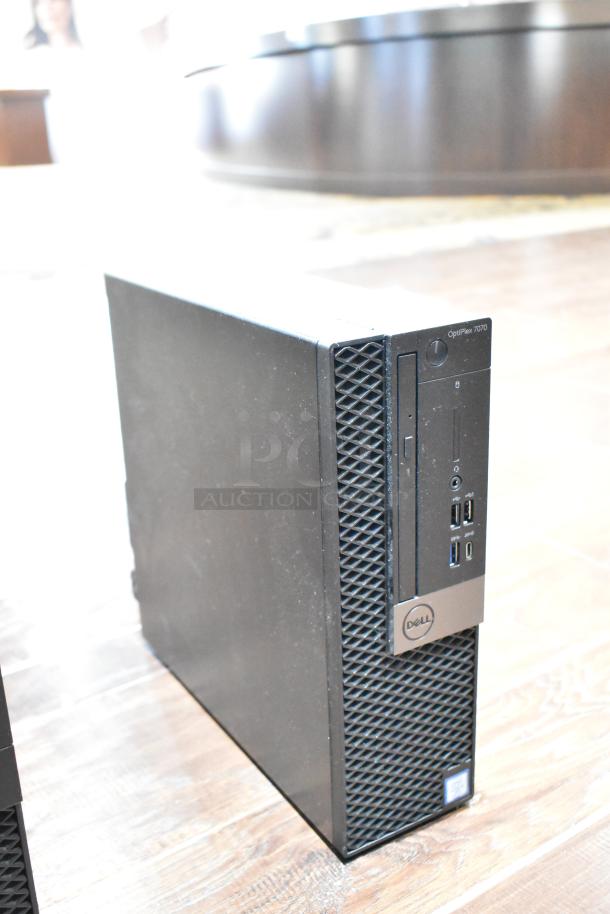 Dell Optiplex 7070 computer tower, black, no hard drive. Front ports visible. Used condition, minor scuffs.