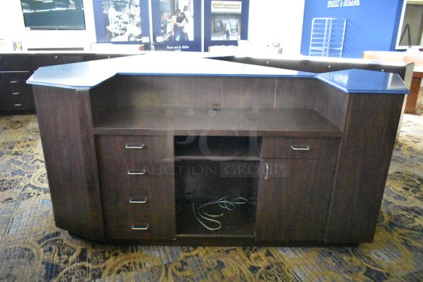 Wooden counter with five drawers and one door, features dark finish, silver handles, built-in shelf, good condition.