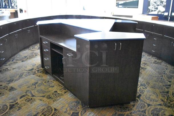 Wooden counter with L-shape design, featuring 5 drawers and 1 door, dark finish, good condition, metal handles.