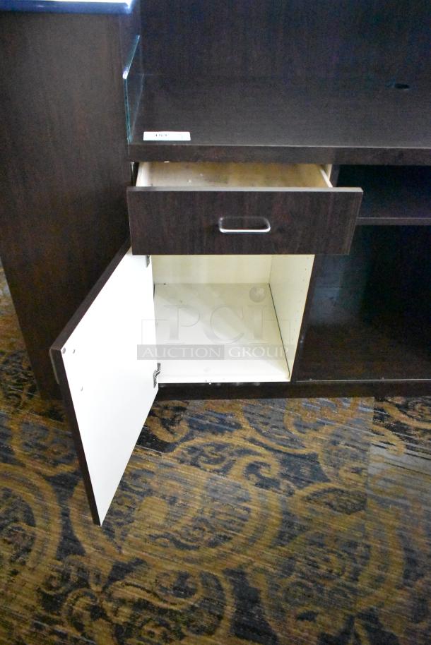 Wooden counter with 5 drawers and 1 door. Dark finish, visible handles, light interior. Excellent storage condition.