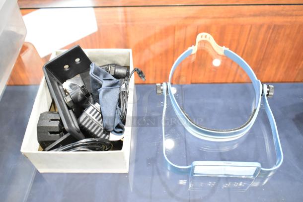 Lot of various items including a blue plastic headband with adjustment knob and a box containing assorted miscellaneous parts.