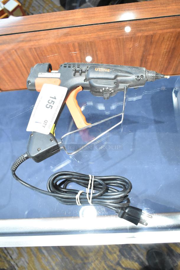 Uline H-1903 Heavy Duty Glue Gun in black and orange, 120 volts, 1 phase, with power cord. Auction tag 155 visible.