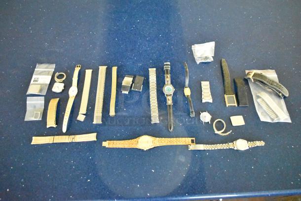 Collection of 27 items including 5 various watches, multiple watch bands, clasps, and accessories displayed on a blue surface.