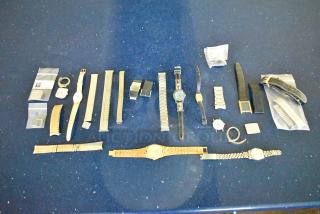 Collection of 27 items including 5 various watches, multiple watch bands, clasps, and accessories displayed on a blue surface.