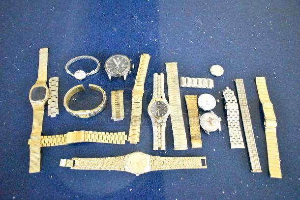 48 assorted watches and bands on a blue surface, featuring various styles and metals, ideal for collectors or resellers.