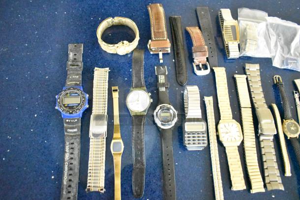 Twenty-three assorted watches and watch bands, various styles and materials, including digital and analog types.