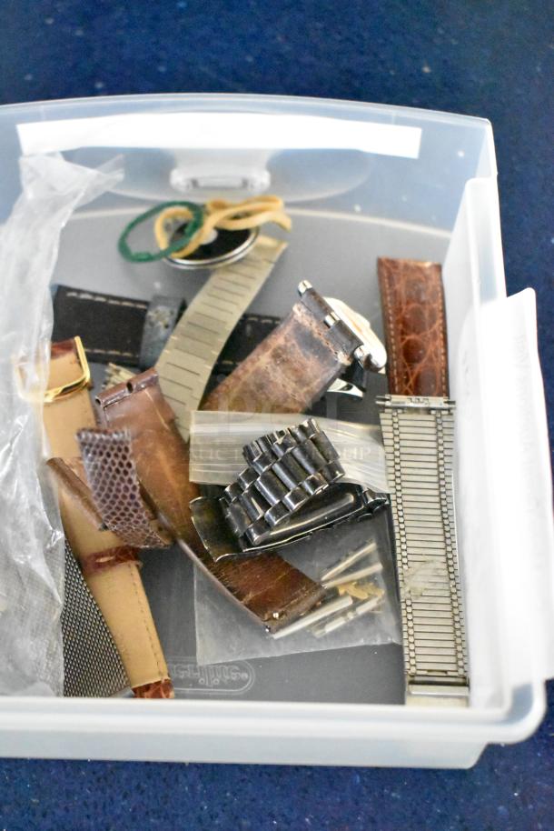 Collection of 32 assorted watch bands and watches in a plastic bin, featuring leather, metal, and rubber straps.