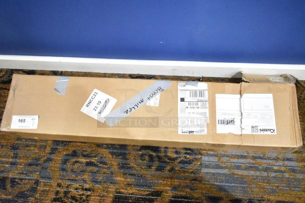 Cardboard box containing iGuzzini Lido Lighting fixture, sealed with shipping labels and duct tape, resting on carpet.