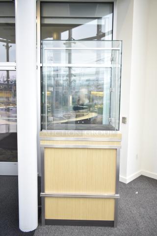 Wooden corner jewelry display case with glass top, oak finish, metal accents, and lockable doors. Buyer must remove.