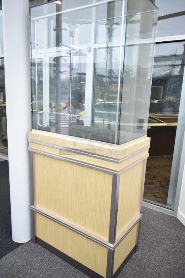 Wooden corner jewelry display case with glass doors, metal accents, and a sturdy base. Requires tools for removal.