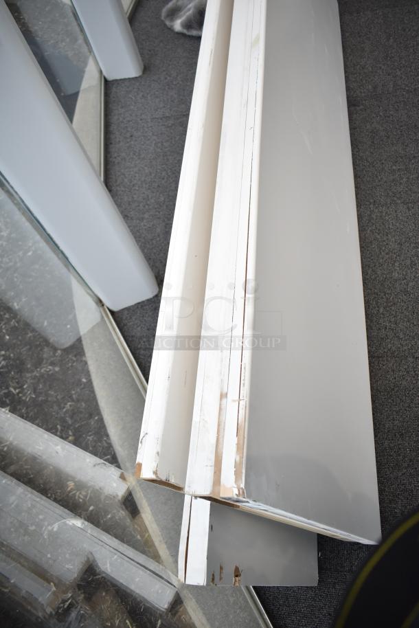 Four white panels stacked, showing some wear at edges. Ideal for construction or decor projects. Good condition.