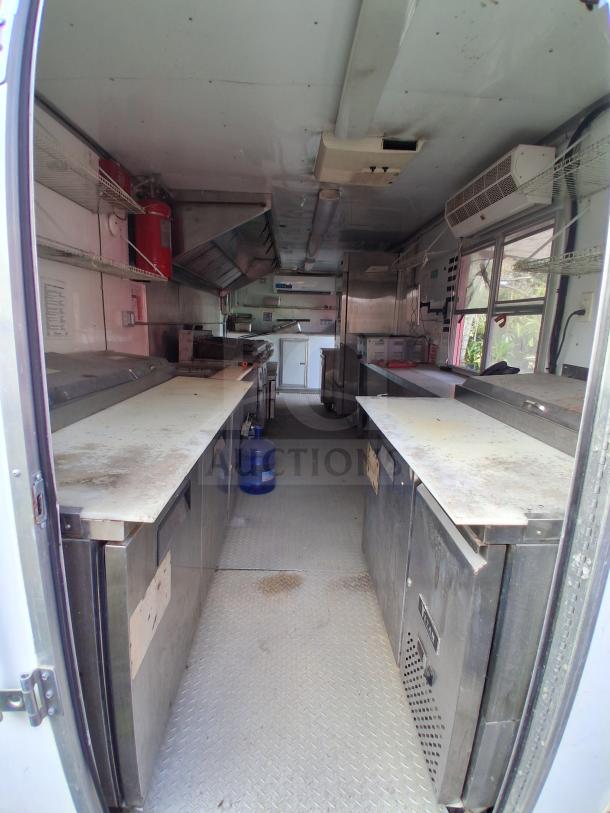 Mobile food trailer with cooking equipment, including a grease hood system, Royal Range, Avantco griddle, gas fryer, and refrigeration.