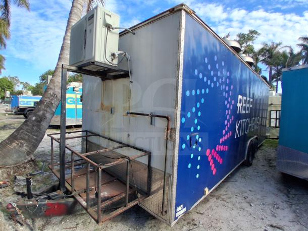 Food trailer with grease hood system, Royal Range, Avantco griddle and fryer, four-unit refrigeration, "REEF Kitchens" branding.