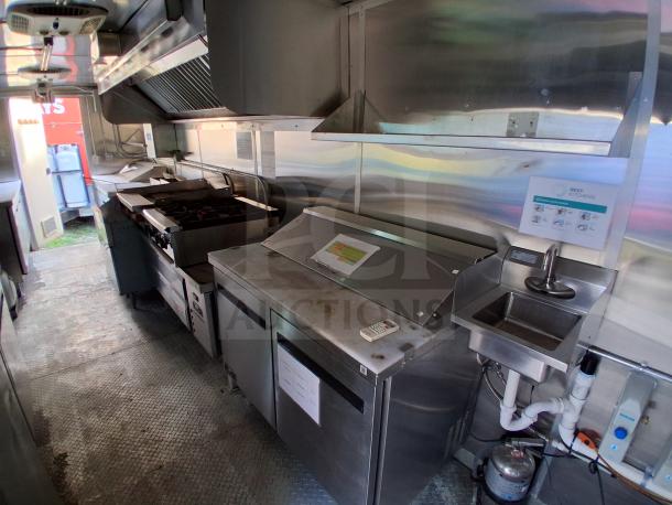 Commercial kitchen trailer with grease hood, Dean fryers, Sierra griddle, Wells 4-burner cooktop, Arctic Air refrigeration suite.