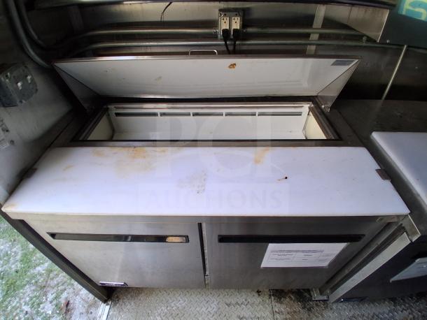 Commercial kitchen trailer refrigeration unit, Arctic Air brand, stainless steel, visible wear, interior view with open lid.