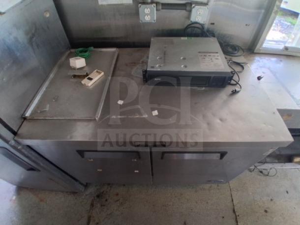 Commercial kitchen trailer interior with stainless steel countertop, visible equipment including APC unit, in used condition.