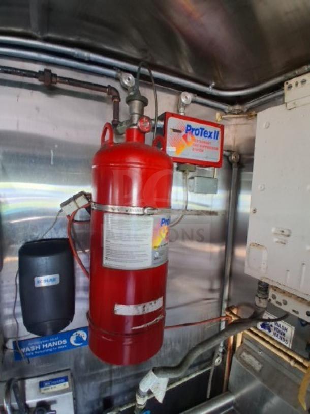 Commercial kitchen trailer interior showing a ProTexII fire suppression system and hand wash station.