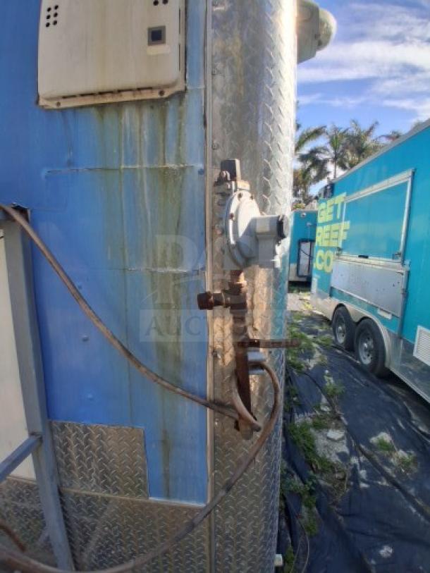 Commercial kitchen trailer featuring large order window, grease hood, dual fryers, griddle, burner cooktop, and refrigeration suite.