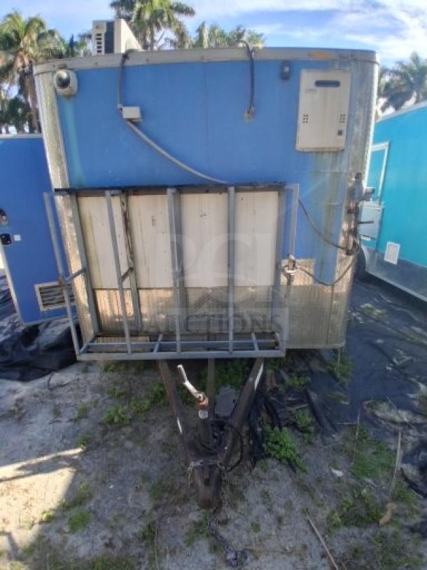 Commercial kitchen trailer with large order window, grease hood, dual fryers, griddle, burner cooktop, and refrigeration suite.