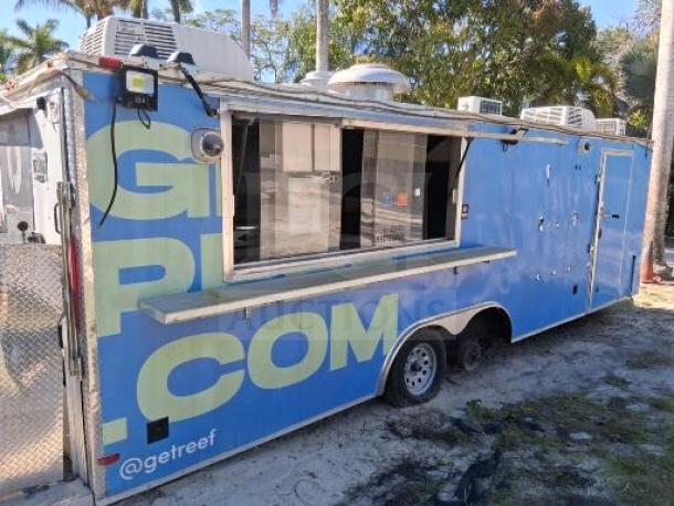 Blue food trailer with large serving window, commercial kitchen equipment, and utility systems. Needs some improvements. “@getreef” branding visible.