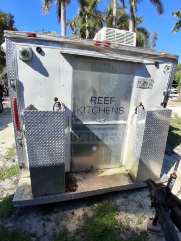 Food trailer with "Reef Kitchens" branding, dual metal panels, utility hook-up, designed for street vending; some improvements needed.