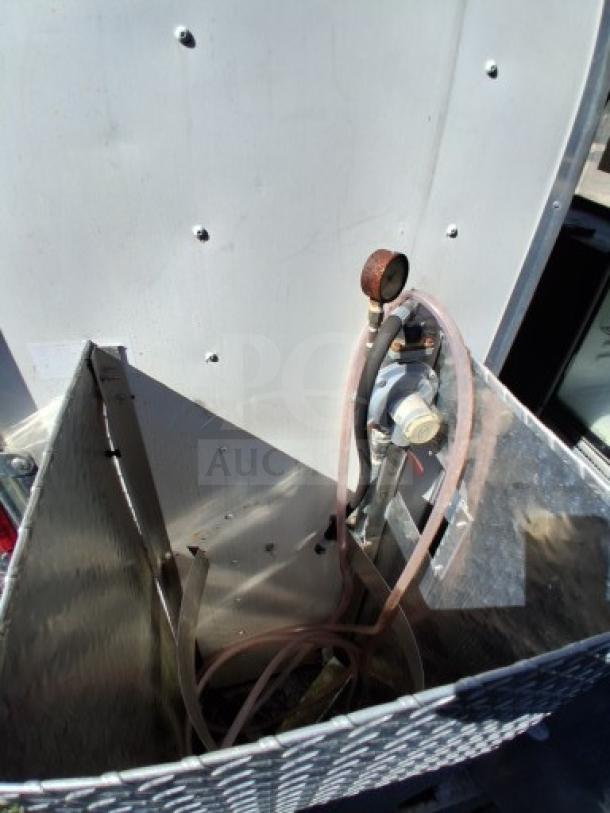 Food trailer utility setup with gas regulator and hose connections. Reflects essential equipment for operational efficiency.