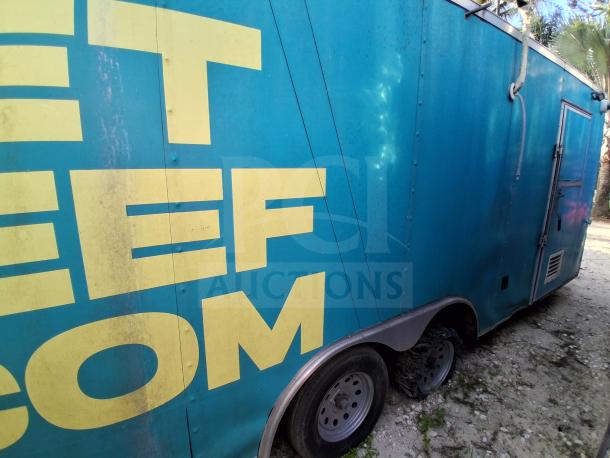 Blue mobile kitchen trailer with yellow lettering, dual wheels, and side vents. Equipped with premium refrigeration, fire suppression, and climate control. Model F106.