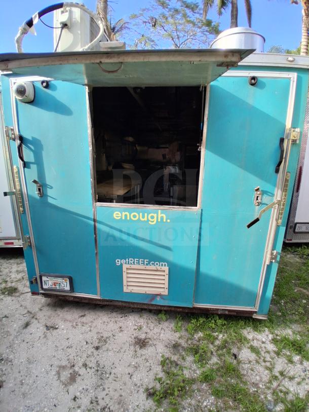 Blue mobile kitchen trailer with open door, featuring premium commercial refrigeration, fire suppression, and climate control. Marked "getREEF.com."