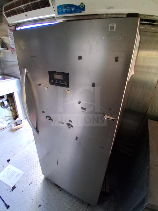Stainless steel commercial refrigerator in food trailer, features digital controls. Ideal for high-volume service.