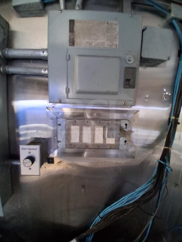 Control panel inside the fully loaded mobile kitchen trailer, featuring wiring and a Vari-Speed dial for climate control.