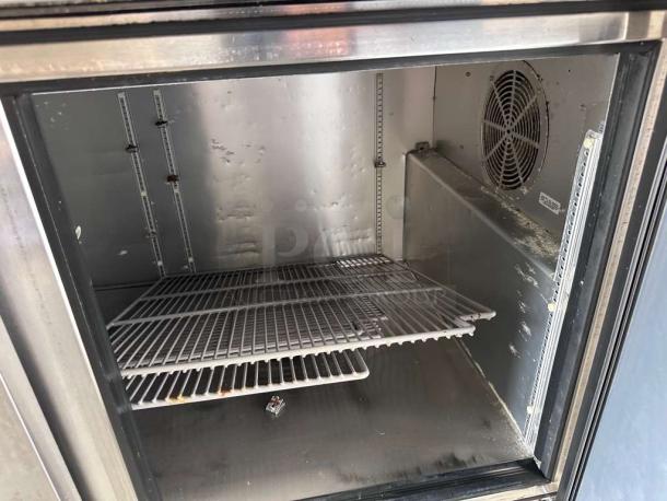 True TPP-AT-67-HC Pizza Prep Table Refrigerator interior, shelving and fan visible, in outstanding condition.