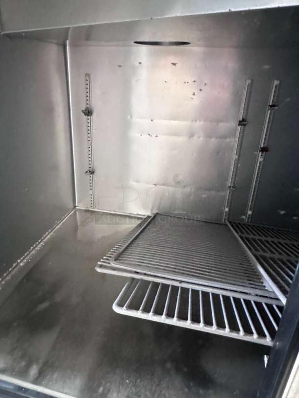 Outstanding condition True TPP-AT-67-HC pizza prep refrigerator interior with shelves, fully operational.
