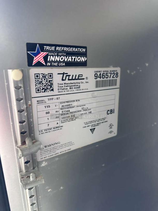 Label on True TPP-AT-67-HC Pizza Prep Table, shows model, voltage, refrigerant details, and "Made in the USA" innovation sticker.