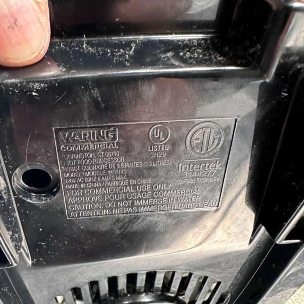 Waring WFP14S commercial food processor base showing labels with model, voltage details, and caution note.